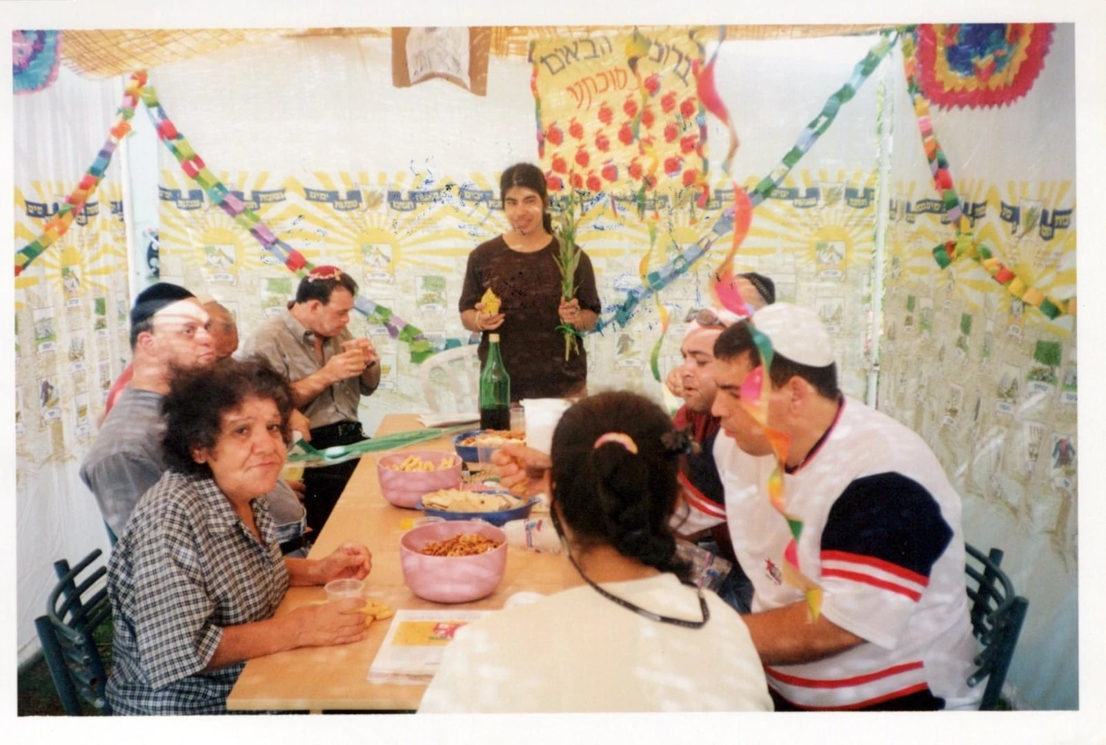 Жильцы хостеля за праздничной трапезой в Суккот